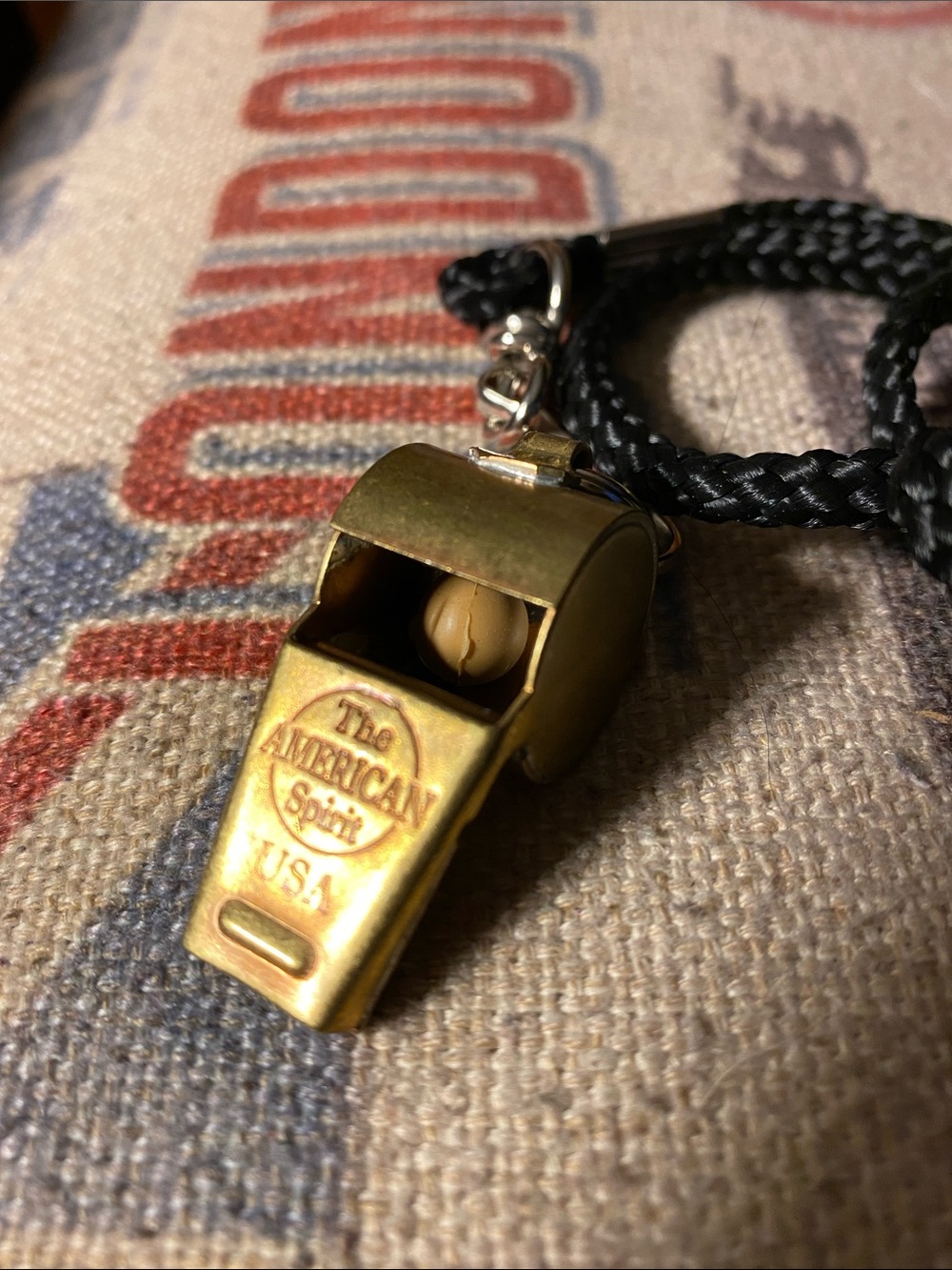 This brass-toned metal whistle features the "The AMERICAN Spirit USA" logo